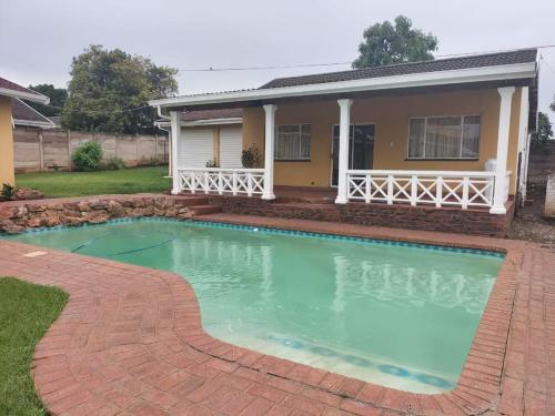 a house with a swimming pool in front of a house at Restwell Accommodation in Pietermaritzburg