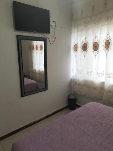 a bedroom with a mirror and a tv on the wall at Restwell Accommodation in Pietermaritzburg