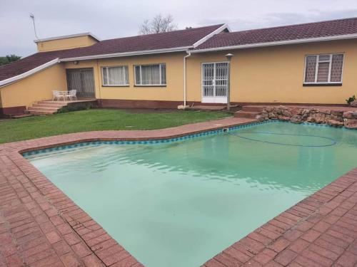 una piscina frente a una casa en Restwell Accommodation, en Pietermaritzburg