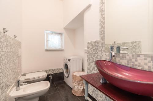 baño con lavabo rojo y aseo en La CORTE di GIO' 2, en Nave