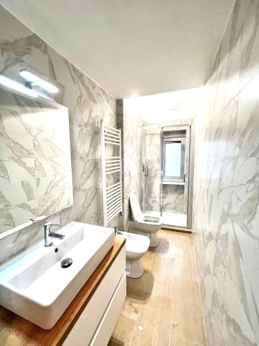 a bathroom with a white sink and a toilet at A due passi da Brignole in Genoa