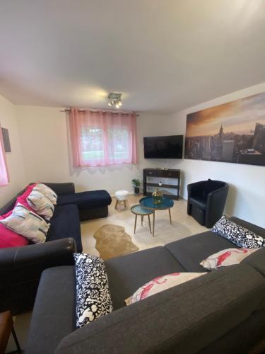 a living room with two couches and a piano at La maison Girafe in Faverolles