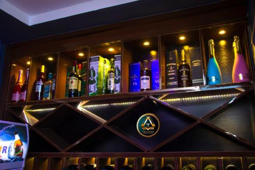 un bar con botellas de alcohol en un estante en TRILLIONS HOTEL AND APARTMENT, en Benin City