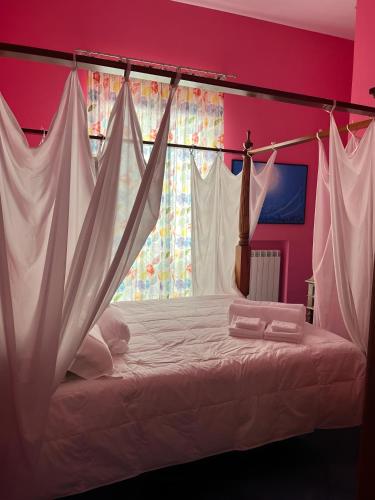 a bedroom with a bed with white sheets and a window at The Rooftop Terrace b&b Two Double Rooms with private bathrooms and an equipped roof terrace in Sant'Agnello