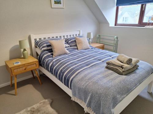 a bed with a blue and white striped comforter in a bedroom at Two bedroom apartment close to the beach in Beer
