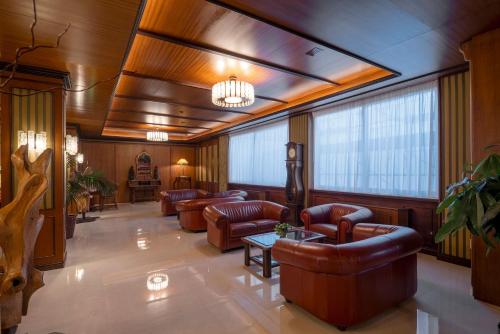 a lobby with leather furniture and large windows at Hotel Delle Palme in Lecce