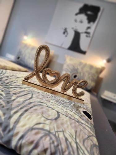 a bed with a heart sign on top of it at Ferienwohnungen Abendsonne - 8 Gehminuten zum EP in Rust