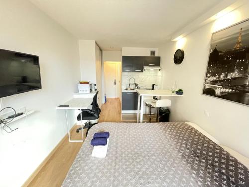een kleine kamer met een bed en een keuken bij Exclusive Private Apartment by Warilco - Pleyel 25 m2 - À 1 minute de la station métro Carrefour Pleyel in Saint-Denis
