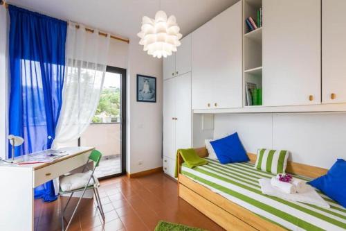 サンレモにあるAppartamento Copacabana vista mare e parkingのベッドルーム1室(青と緑の枕が備わるベッド1台付)