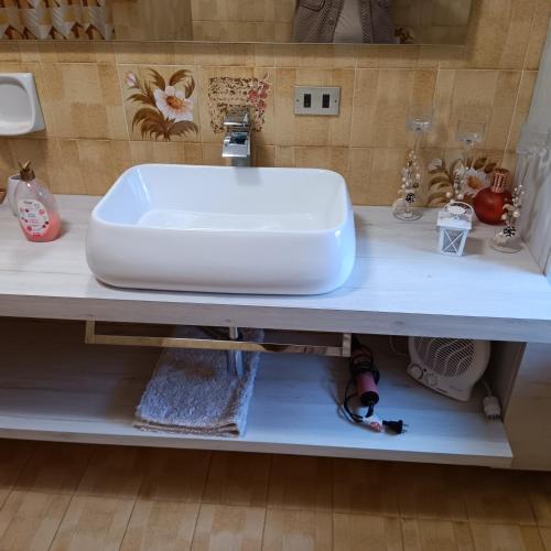 a bathroom counter with a white sink on a shelf at Il Sentiero in Verona