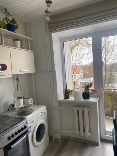 a kitchen with a washing machine and a window at OLD TOWN in Kėdainiai