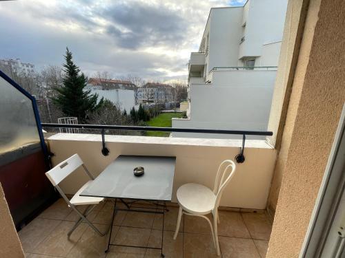 a small balcony with a table and two chairs at Exclusive Private Apartment by Warilco - Pleyel 25 m2 - À 1 minute de la station métro Carrefour Pleyel in Saint-Denis