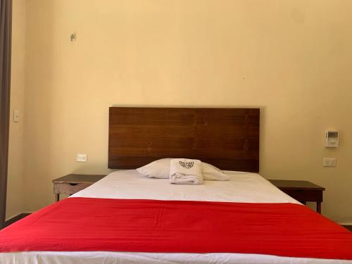a bedroom with a large bed with a red blanket at Casa Delfín Tulum in Macario Gomez