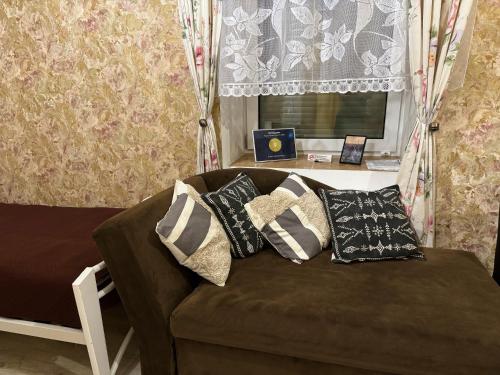 陶格夫匹爾斯的住宿－Sofija apartamenti，客房内的棕色沙发上配有枕头