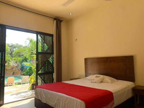 a bedroom with a bed and a large window at Casa Delfín Tulum in Macario Gomez
