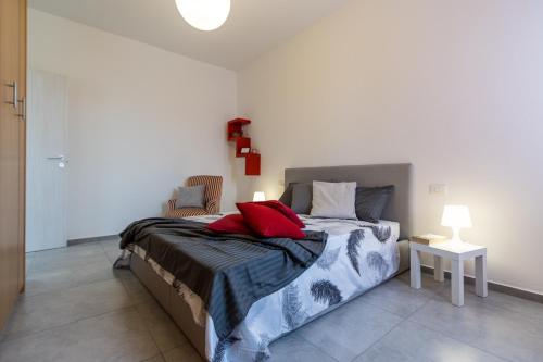 ein Schlafzimmer mit einem Bett mit roten Kissen darauf in der Unterkunft Arona 85 - Cozy apartment - Wi-Fi - NETFLIX in Arona