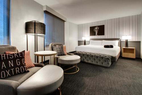 a hotel room with a bed and a couch at The Rose Chicago, Tapestry Collection By Hilton in Rosemont