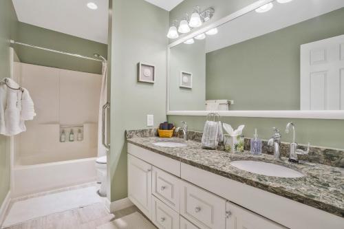 a bathroom with two sinks and a large mirror at Gorgeous Creek Side Ranch-Style Estate With Dock in Grasonville