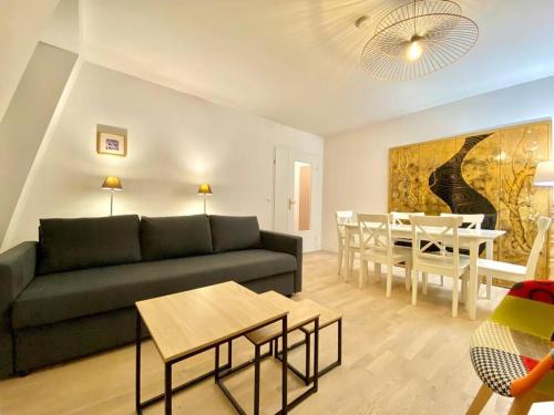 a living room with a couch and a dining room at Suite Médicis Near Disneyland in Serris