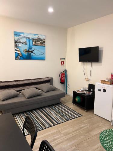 ein Wohnzimmer mit einem Bett und einem Flachbild-TV in der Unterkunft River Place in Porto