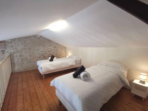 une chambre avec deux lits dans un grenier dans l'établissement Le Baleineau au cœur de Saint Martin de Ré, à Saint-Martin-de-Ré