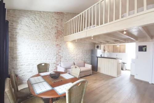 une salle à manger avec une table et des chaises et une cuisine dans l'établissement Le Baleineau au cœur de Saint Martin de Ré, à Saint-Martin-de-Ré