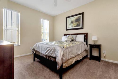 a bedroom with a large bed and a window at Villas at Regal Palms-4 Bedroom3.5 bath Townhouse in Davenport
