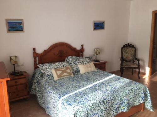 - une chambre avec un grand lit et une chaise dans l'établissement Villaricos, à Villaricos