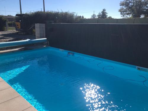 una piscina azul con una valla negra en LES RONCES, 