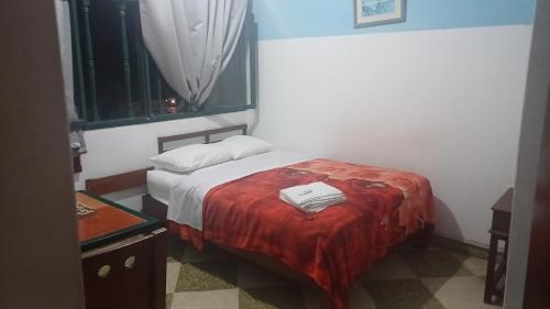 um quarto com uma cama com um cobertor vermelho em Julia house em Huanchaco