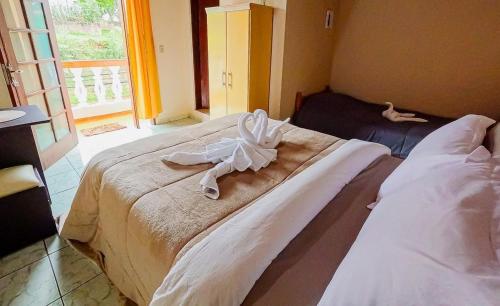 a bedroom with two beds with towels on them at Pousada São Benedito in Santo Antônio do Pinhal