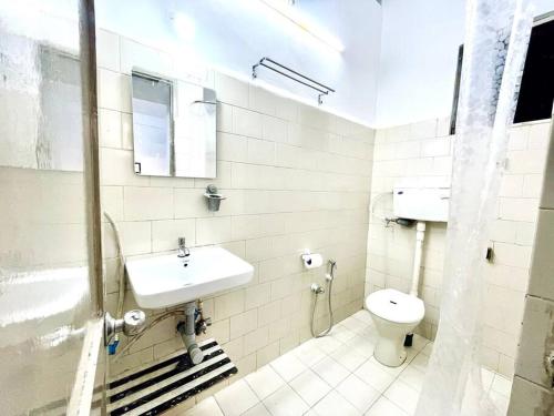 a white bathroom with a sink and a toilet at Luxurious 1BHK with a Pool AniRah Homes in Colva in Colva