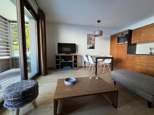 un salon avec un canapé et une table dans l'établissement Appartement coeur des Saisies, à Hauteluce