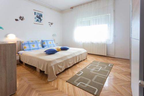 a bedroom with a bed with blue pillows and a rug at Nice and spacious apartment- Silvio 2 in Banjole