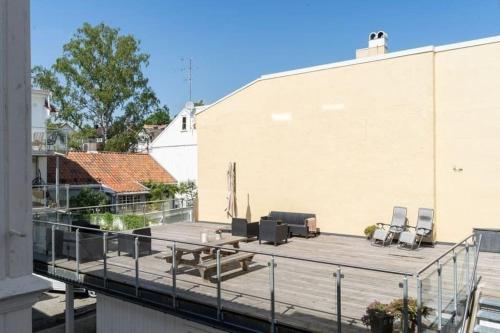 a deck with chairs and a table on a building at MyCondo no - Storgt 15b in Tønsberg