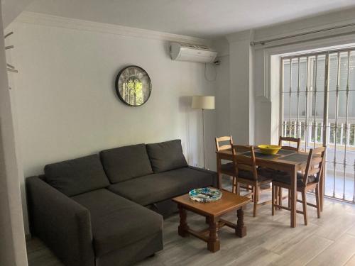 ein Wohnzimmer mit einem Sofa und einem Tisch in der Unterkunft Mar y sol in Benalmádena