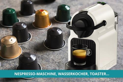 a espresso machine with a cup of coffee at Apt Wahnfried Nr1 - Cityapartment mit Küche, Duschbad, Balkon, Parkplatz - zentral aber ruhig in Bayreuth