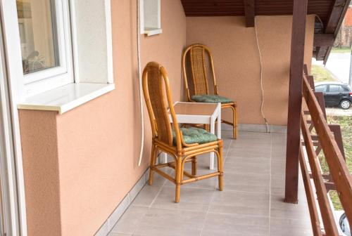 two chairs sitting on a porch next to a window at Vesna in Vukovar
