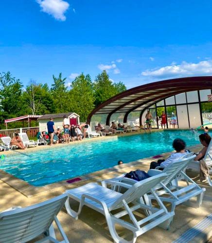 - un groupe de personnes assis sur des chaises au bord de la piscine dans l'établissement Bungalow charmant près d'Onzain avec piscine partagée, à Onzain