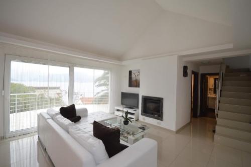 a white living room with a white couch and a fireplace at Natalie Apartments in Tivat