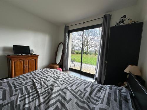 a bedroom with a bed and a sliding glass door at chambre équipée in Panazol