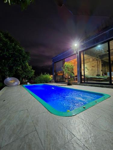 a swimming pool in a backyard at night at The Box Promkiri (เดอะบ๊อค พรหมคีรี) in Ban Pak Ram