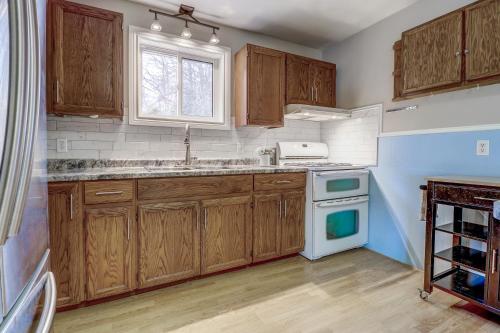 a kitchen with wooden cabinets and a sink and a window at Lakehouse chalet on Sky Lake Ontario 5 bedrooms in Red Bay