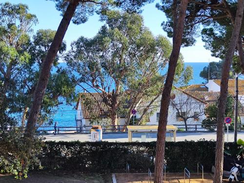 uma vista para a água a partir de um parque com árvores em Apartamento con VISTAS AL MAR y jardín a 150 metros de la playa em Sant Antoni de Calonge