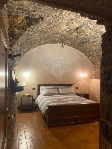 - une chambre avec un lit dans un mur en pierre dans l'établissement La piccola Corte, à Roncola