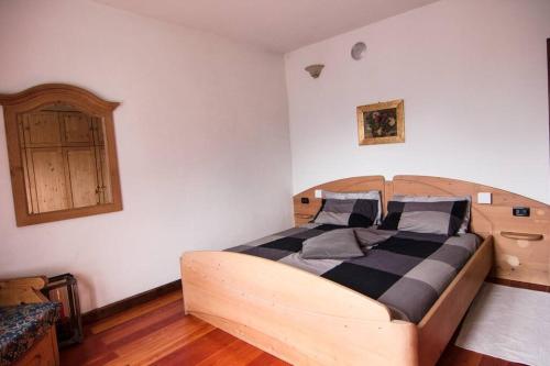 a bedroom with a bed with a wooden headboard at Reddish Deer House ::: Cadore Dolomiti in Valle di Cadore