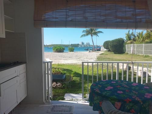 a bedroom with a view of the beach from a window at Just in paradise in Baie Nettle