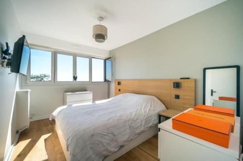 une chambre avec un lit, un bureau et des fenêtres dans l'établissement Bel appartement 2P proche Paris, à Fontenay-aux-Roses