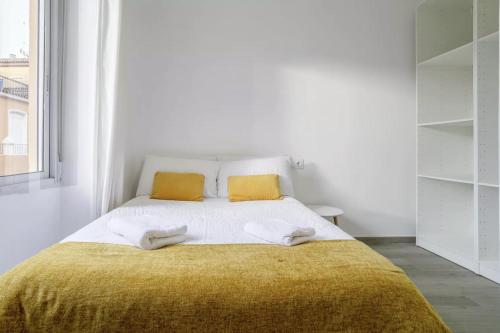 um quarto branco com uma cama grande e 2 almofadas amarelas em Very nice and modern flat, in Alicante Center em Alicante