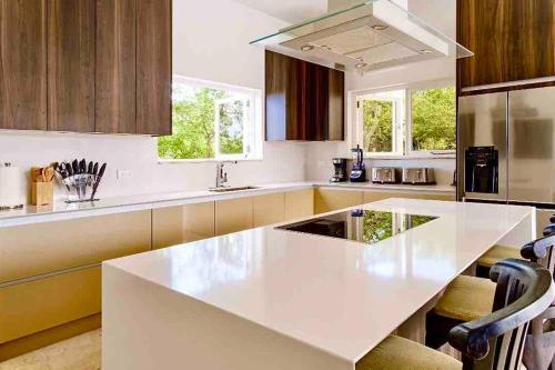 a white kitchen with a large white counter top at NewVilla-Coral Estate-WalktoBeach-Private Pool-up to 16 Guests SeaView in Willibrordus